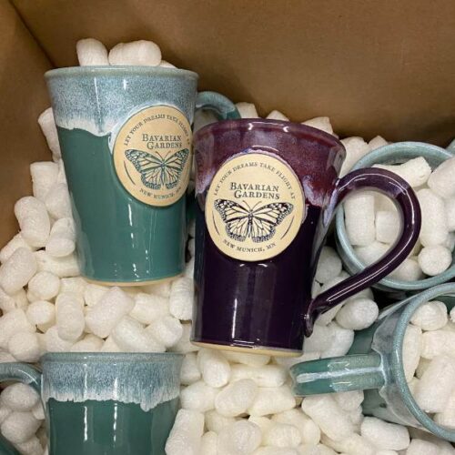 purple and green coffee mugs in a box with shipping peanuts