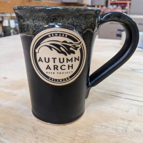 black tall coffee mug with logo