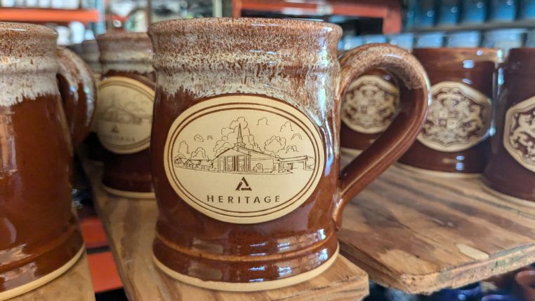 brown ceramic coffee mug with a logo for a church