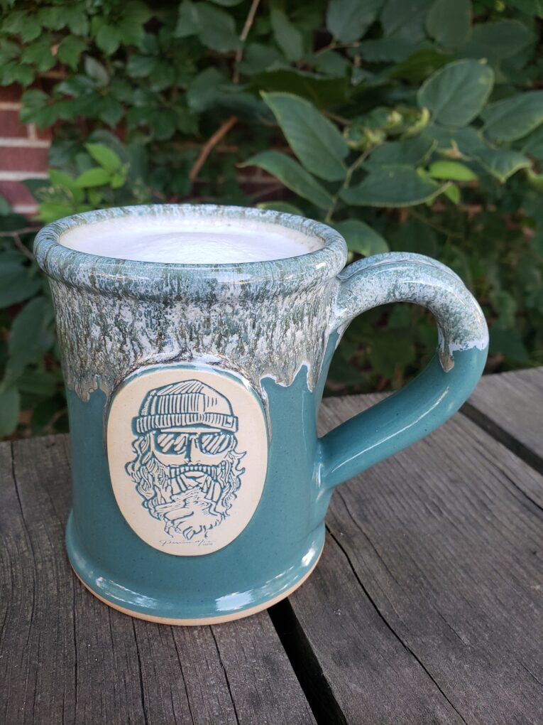 teal ceramic mug with coffee and cream