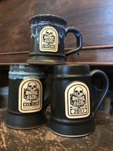 Stack of three beer steins on a wood table.