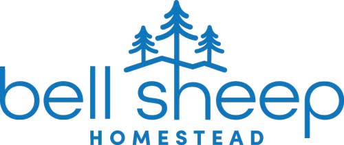 Text "bell sheep Homestead" with a group of illustrated pine trees at the top.