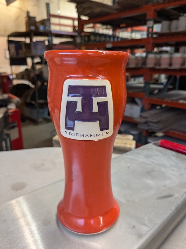 orange pilsner beer stein with a logo for a brewery