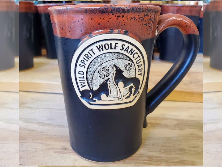 Black handmade logo coffee mug with orange accent on rim.