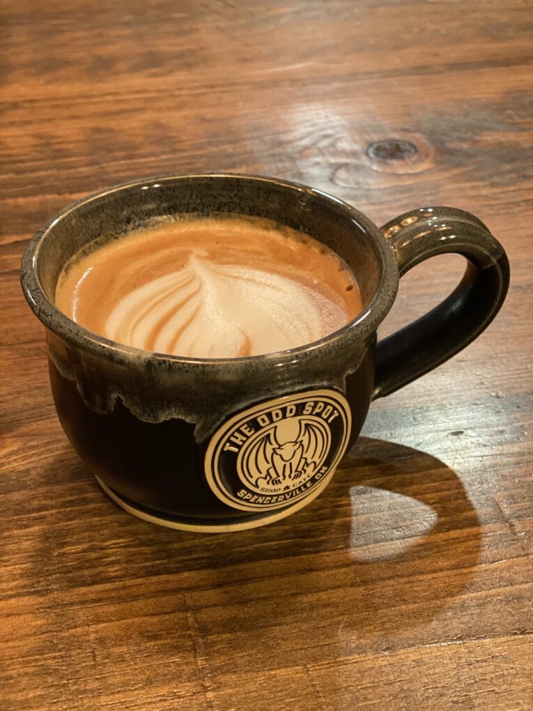 Large coffee mug filled with coffee and cream.