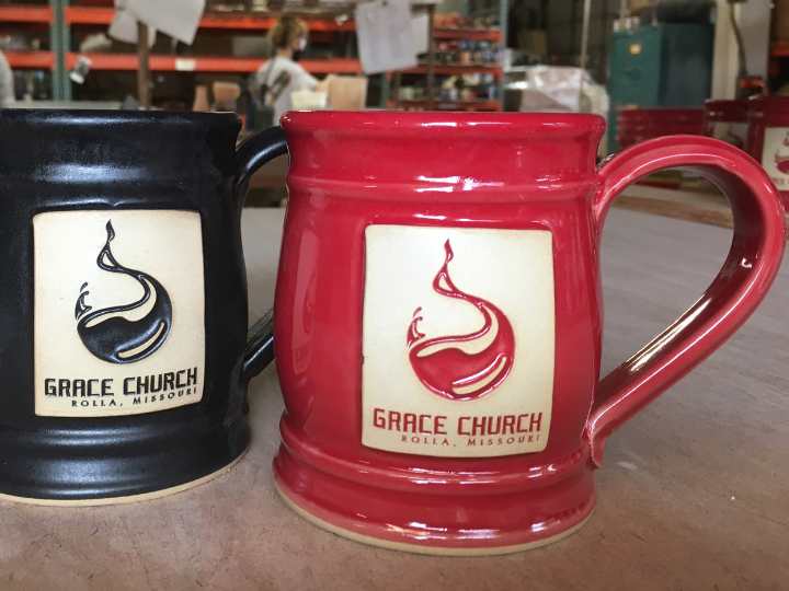 Red and black coffee mugs with "Grace Church" logo.