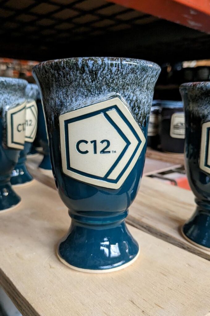 Tall chalice style handmade mug with clay medallion featuring the text "C12".