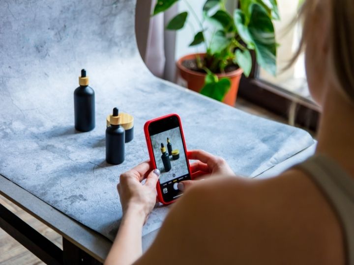 person using their mobile phone to take product photos