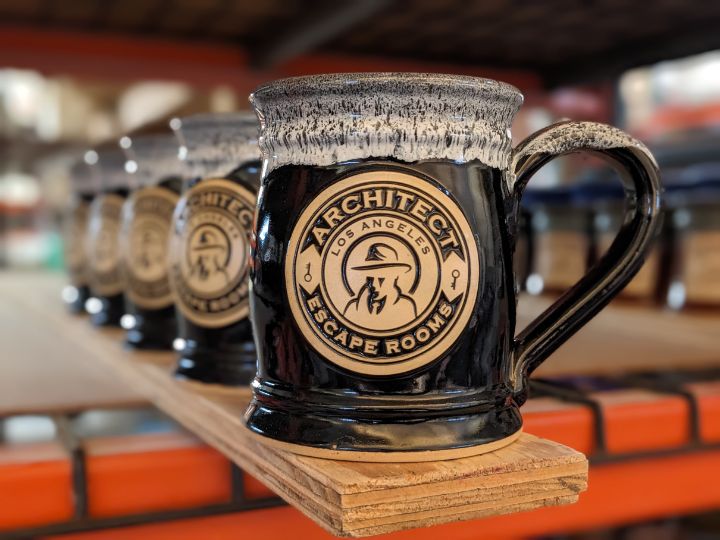 Black handmade coffee mug with logo of architect escape room