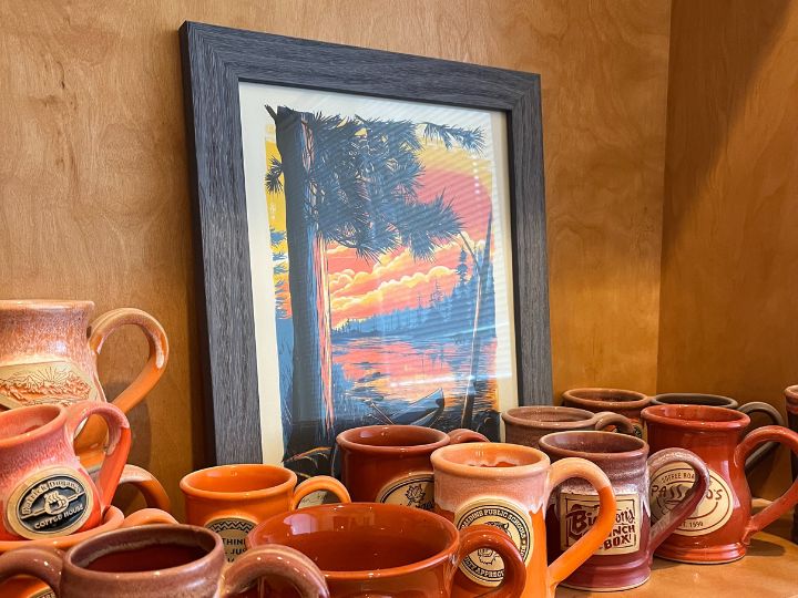 Nature scene Art print on a shelf behind a group of coffee mugs