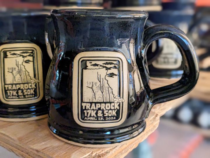 dark blue coffee mug with a logo for taprock 17k race