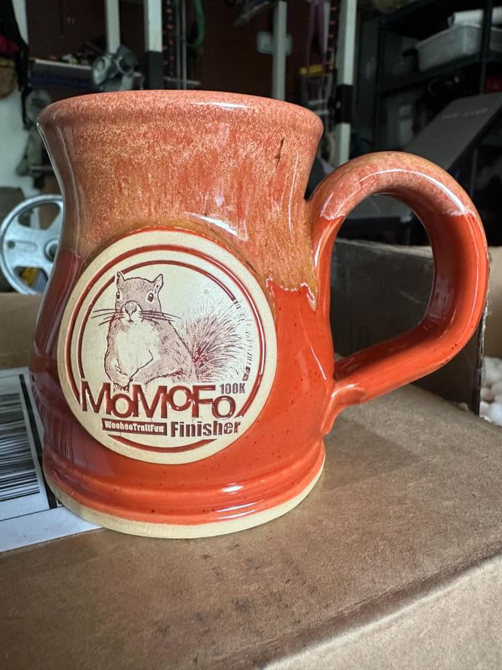 Red coffee mug with clay medallion of a squirrel and text MoMoFo race