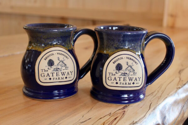 two blue coffee mugs with a logo for Gateway Farm