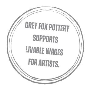 text 'grey fox pottery supports livable wages for artists' surrounded by a grey circle